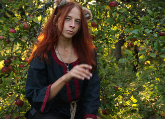 Selfie portraits of a red-haired woman with a fluffy tail and ears in the summer outdoors in an...
