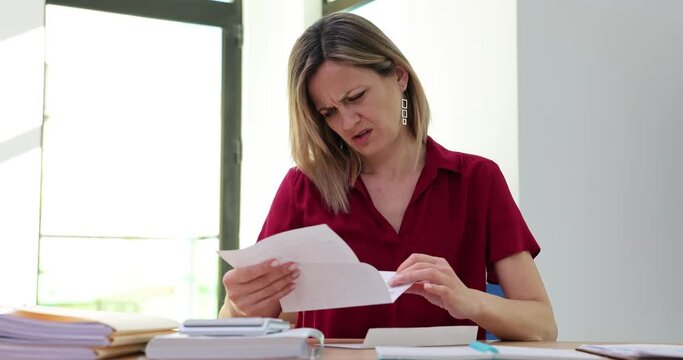 Blonde woman opens letter and becomes outraged by content