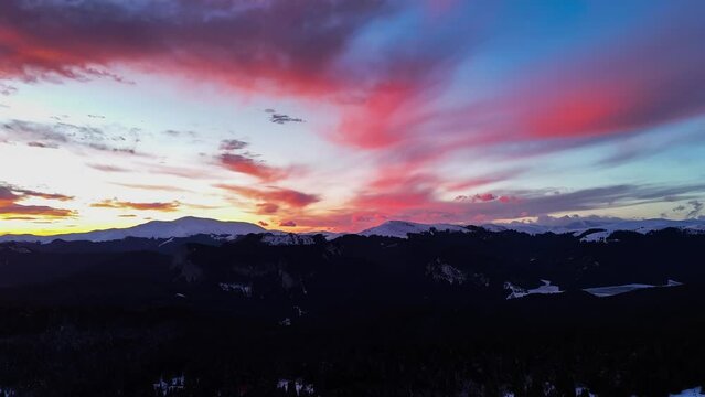 Aerial hyper lapse of Carpathian mountains in Romania, at sunset in the winter season