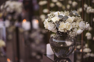 View of elegant expansive white flowers and andles decoration for wedding party. the wedding ceremony in the open air of fresh flowers, with candles. Luxury and beautiful wedding decor. Decor details.