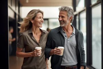 Deurstickers Middle aged couple at indoors holding a take away coffee © luismolinero