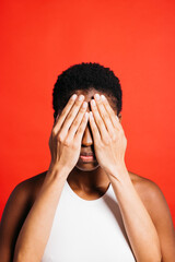 Portrait of young woman with her eyes covered by another woman's hands.