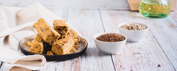 Sweet dessert halva from sunflower seeds with flax seeds on a plate web banner