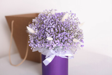 Bouquet of beautiful violet flowers and box on white background