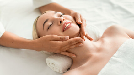 Young Blonde Woman Enjoying Relaxing Massage Lying On Bed Indoors