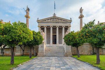 Academy of Athens with marble columns with sculptures of Apollo and Athena and tangerine trees in...