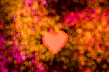 Red paper heart on a black background with blurred golden glitters, decorations for Valentine's Day, Mother's Day. Textures
