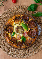 Cheese and eggplant cake, cherry tomatoes and basil leaves. Top view