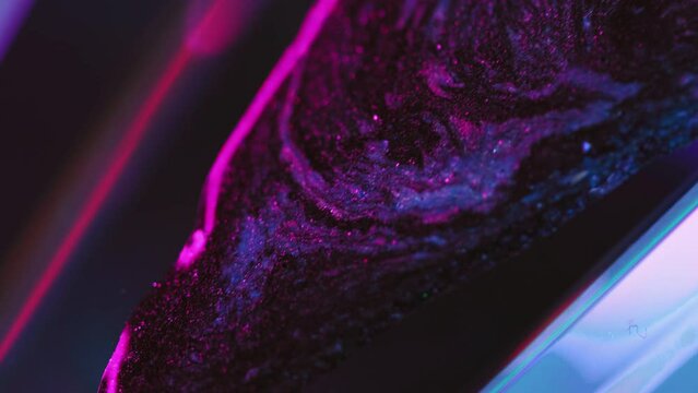 Glitter paint drip. Neon ink spill. Cyber fluid. Defocused fluorescent pink blue color glowing sparkling texture liquid flow motion abstract art background.