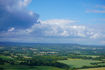 Obraz premium Views over countryside farm fields with clouds in blue sky in the summer