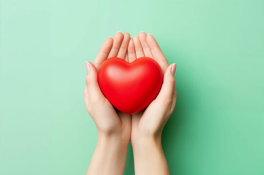 illustrative photo of two hands holding a red heart