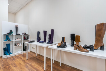 White shelves with women's shoes in a modern showroom with light walls.