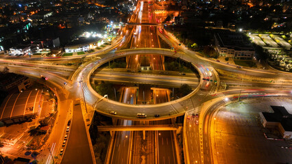 Aerial drone slow shutter night photo of illuminated urban elevated toll ring road junction and...