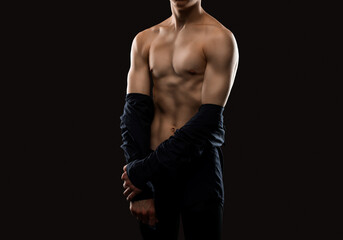 Handsome sexy man with a pumped up body in a dark shirt on a black background. Sports and healthy...