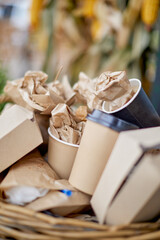 Paper garbage in a basket on the street, disposable tableware in a basket. The trash can is filled with garbage, disposable tableware is discarded, crumpled, used