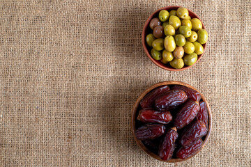Dates fruit and green olives on a burlap sack .Traditional iftar table 