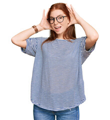 Young read head woman wearing casual clothes and glasses smiling cheerful playing peek a boo with...