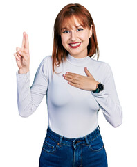 Redhead young woman wearing casual turtleneck sweater smiling swearing with hand on chest and...