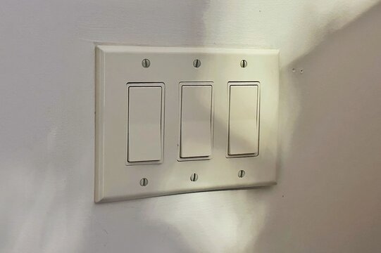 A three gang light switch with rocker switches