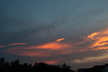 Abstract colorful background. Beautiful red sunset over a small town. Dramatic sunset sky with clouds.
