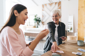 Happy senior multiethnic friends having fun playing card game