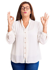 Middle age latin woman wearing casual clothes and glasses relax and smiling with eyes closed doing meditation gesture with fingers. yoga concept.