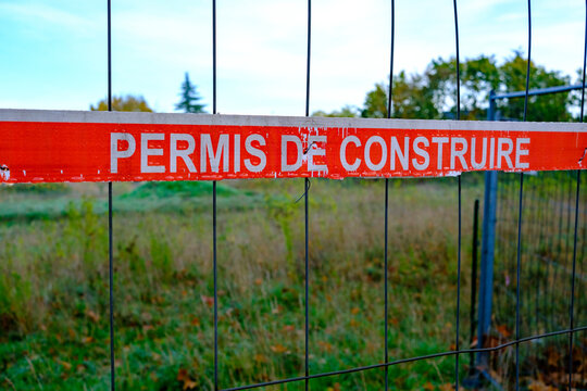 Panneau "permis de construire" sur un grillage