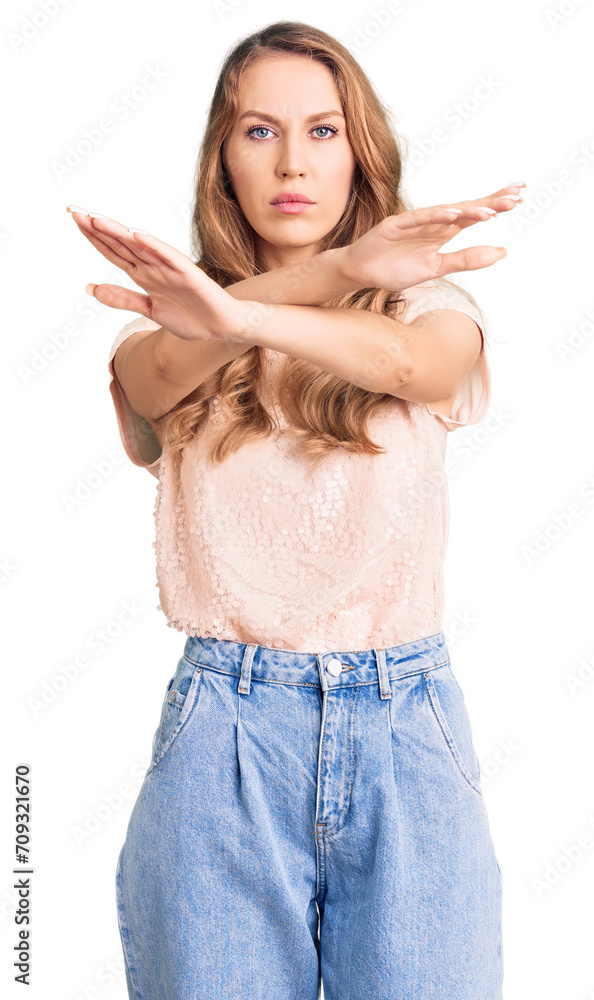 Poster Young beautiful caucasian woman with blond hair wearing casual clothes rejection expression crossing arms and palms doing negative sign, angry face