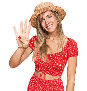 Beautiful caucasian woman wearing summer hat showing and pointing up with fingers number four while smiling confident and happy.
