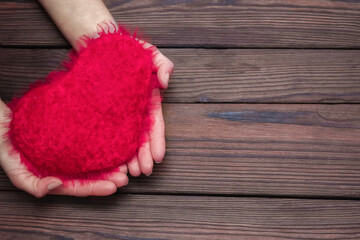 Obraz na płótnie Canvas A Heart in hands on valentine's day on a wooden background holiday