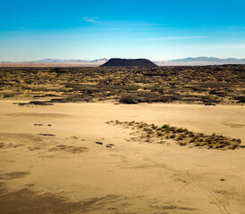 Fototapeta na wymiar Cinder cone and lava field meet sand dunes