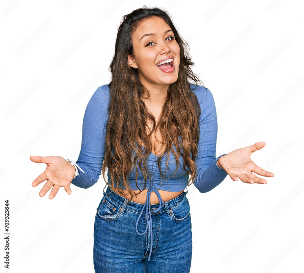 Wall mural Young hispanic girl wearing casual clothes smiling cheerful offering hands giving assistance and acceptance.