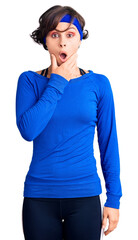 Beautiful young woman with short hair wearing training workout clothes looking fascinated with disbelief, surprise and amazed expression with hands on chin