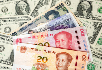 Various banknotes of Chinese and other currency on the dollar bills background