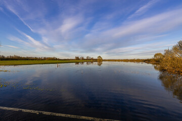 Spring landscape, the sky is reflected in the sky, a field flooded with water during the spring...