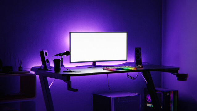 Gaming setup in a dark room with purple neon lights