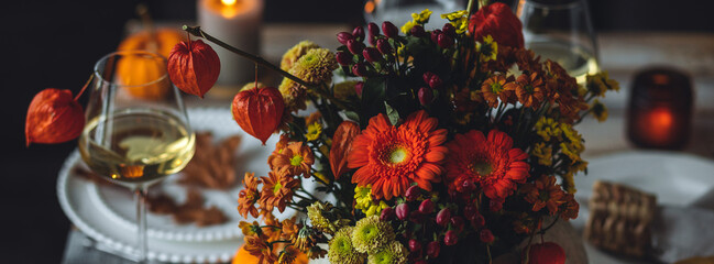 Cozy festive holiday table decor, home family Thanksgiving dinner. Traditional event, elegant natural rustic decoration. Countryside style. Burning candles, floral centrepiece pumpkin banner