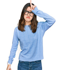 Young beautiful woman wearing casual clothes and glasses making fun of people with fingers on...