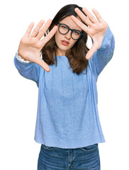 Young beautiful woman wearing casual clothes and glasses doing frame using hands palms and fingers, camera perspective