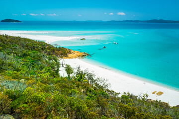 Fototapeta na wymiar Boats transporting tourists to Whitehaven Beach is on Whitsunday Island. . The beach is known for its crystal white silica sands and turquoise colored waters. Autralia, Dec 2019
