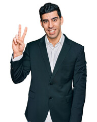 Handsome hispanic man wearing business clothes showing and pointing up with fingers number two while smiling confident and happy.