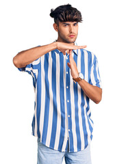 Young hispanic man wearing casual clothes doing time out gesture with hands, frustrated and serious face