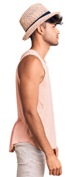 Young hispanic man wearing summer hat looking to side, relax profile pose with natural face with confident smile.