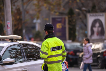 Fototapeta premium A policeman next to a police car in the city