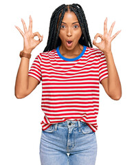 Beautiful hispanic woman wearing casual clothes looking surprised and shocked doing ok approval symbol with fingers. crazy expression