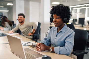 A friendly interracial agent is helping customer on a phone call.