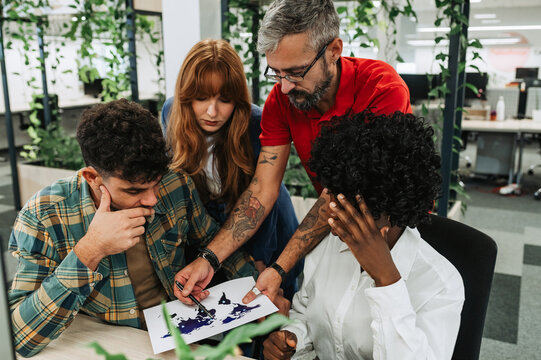 A casual interracial team looking at statistics while working at enterprise.