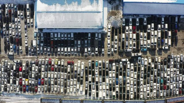 Aerial: parking lot with rows of cars waiting for customs clearance