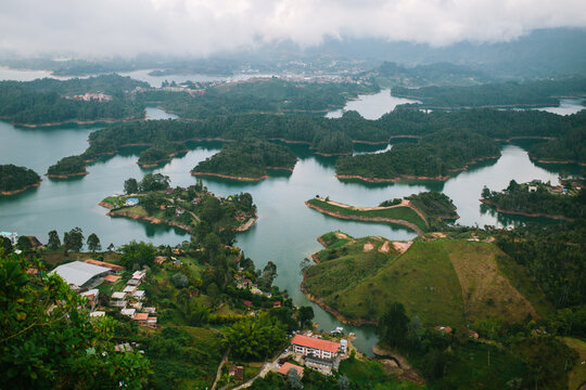 Misty lakeside landscape with lush greenery and settlements in Guatap&eacute;