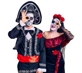 Young couple wearing mexican day of the dead costume over background doing ok gesture with hand smiling, eye looking through fingers with happy face.